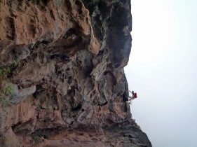 Climbing the corner of a cave on the Via Ferrata La Guagua on Gran Canaria.