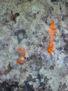 The painted mark and arrow showing the start and direction of orange problem number 2 at Rocher des Potets.